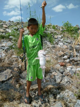 Kind beim angeln in Thailand